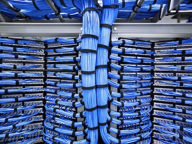 A rack of blue wires in a data center utilized for computer help and digital marketing.