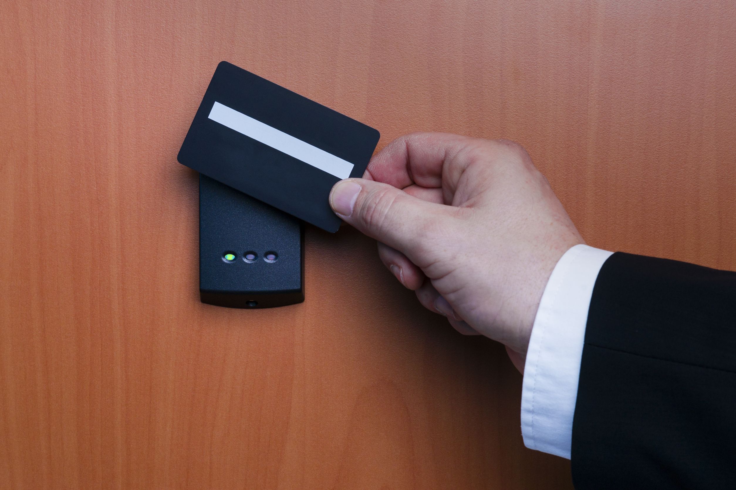 A man in a suit is offering a credit card for phone services at the door.