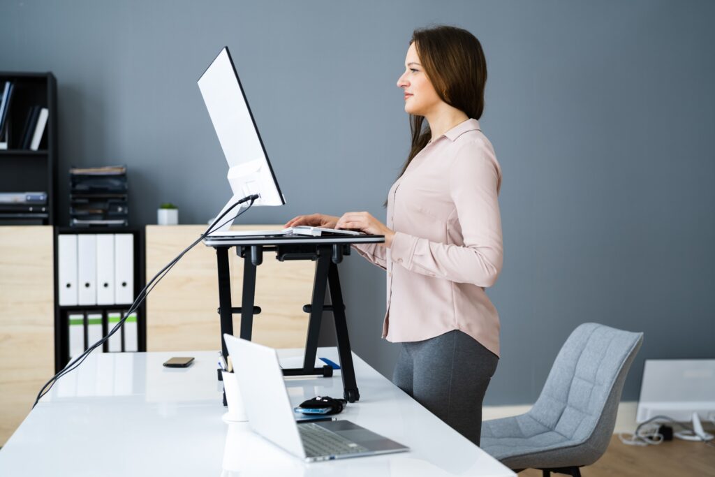 Adjustable Height Desk Stand In Office Using Computer